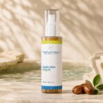 Pearls of Nature Satin Skin Body Oil on travertine beside a reflecting pool